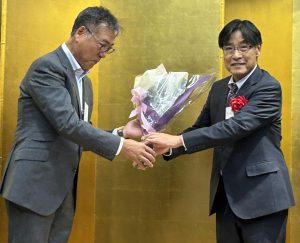 羽鳥好之さんから東圭一さんに花束が贈呈された