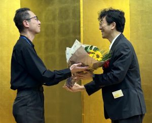 渡邉浩一郎さんから赤神諒さんへ花束が贈呈された